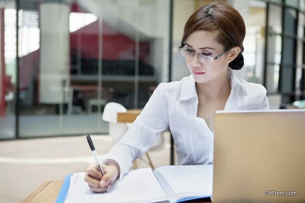 Businesswoman writes on a document
